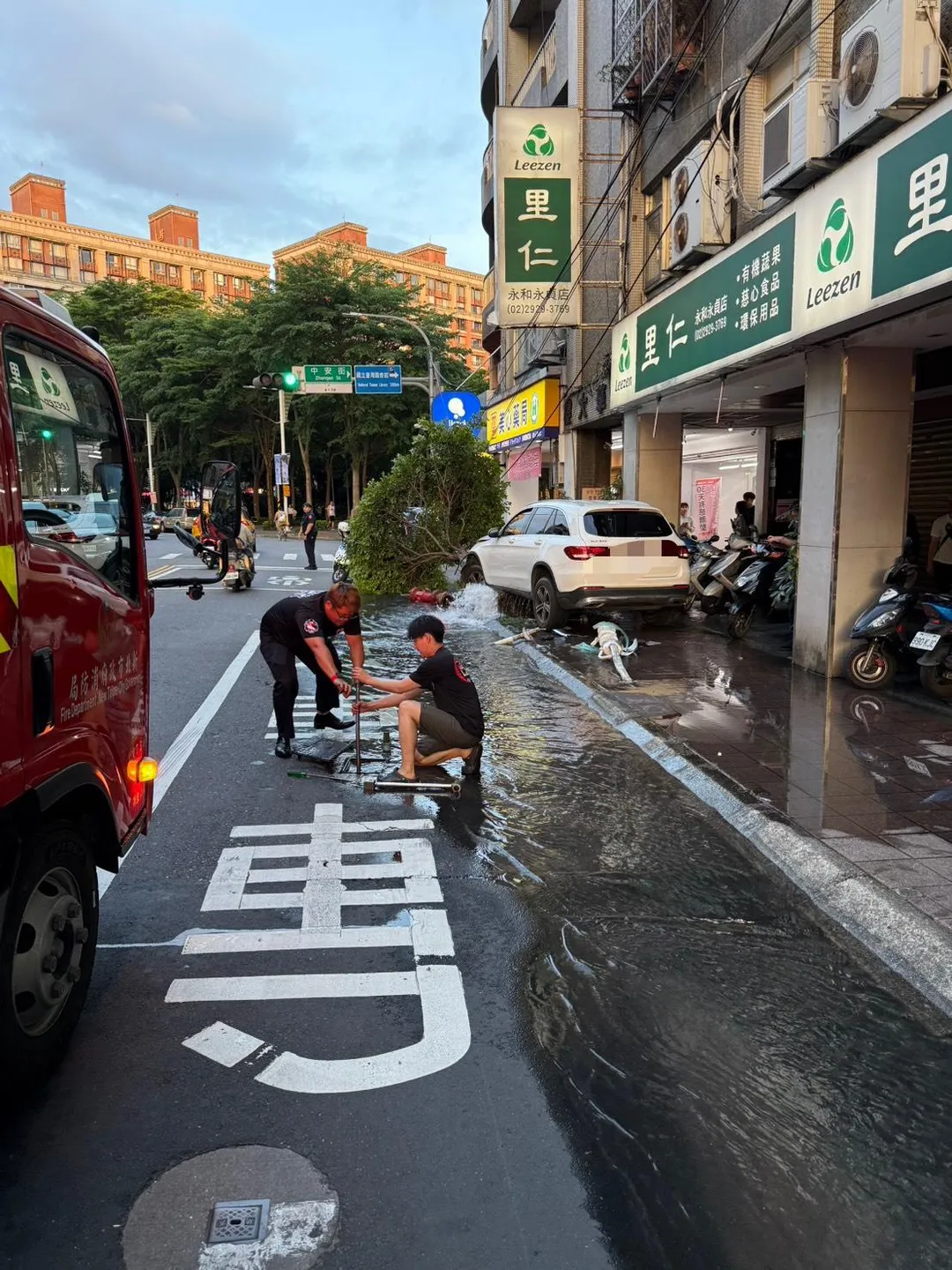中和一輛白色轎車失控衝上人行道，不僅撞斷公車站牌及消防栓，還造成一名正在等候公車的70多歲婦人受傷。（圖／翻攝畫面）
