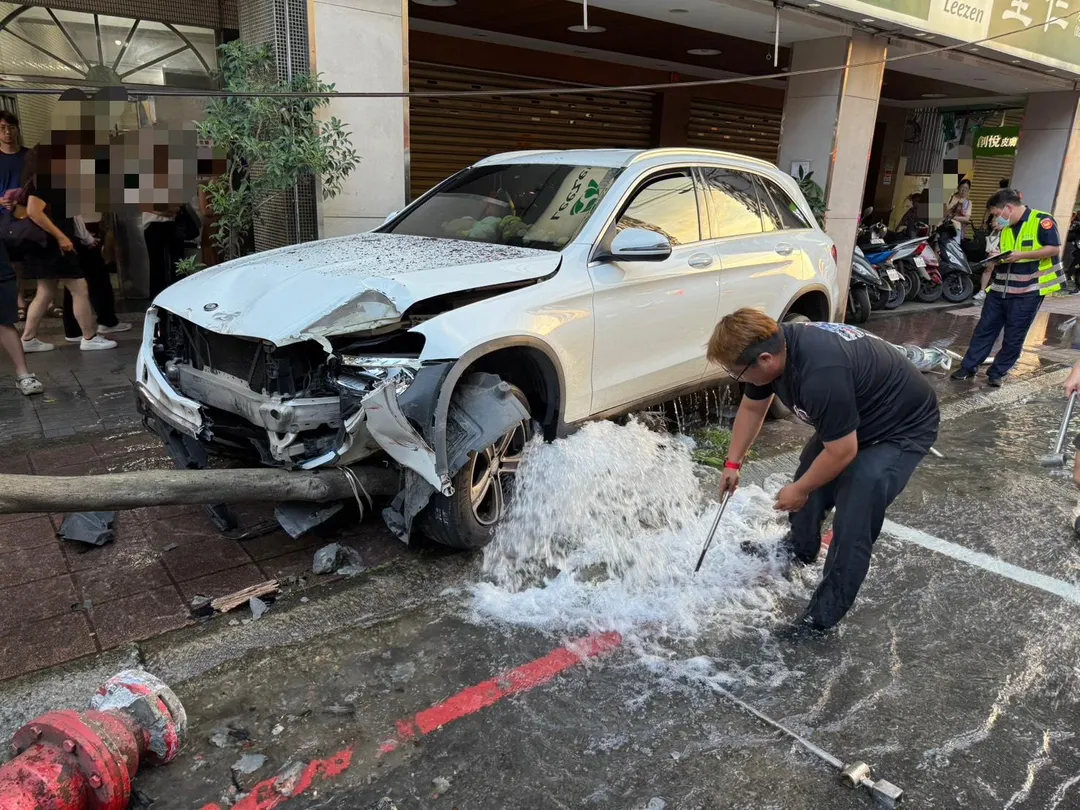 中和一輛白色轎車失控衝上人行道，不僅撞斷公車站牌及消防栓，還造成一名正在等候公車的70多歲婦人受傷。（圖／翻攝畫面）