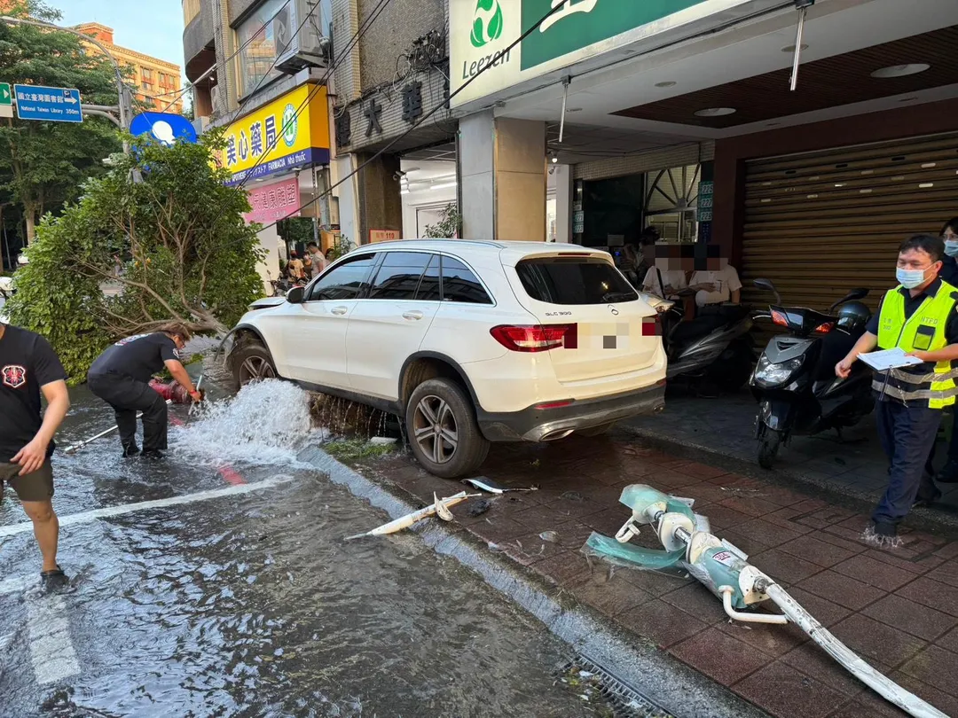 中和一輛白色轎車失控衝上人行道，不僅撞斷公車站牌及消防栓，還造成一名正在等候公車的70多歲婦人受傷。（圖／翻攝畫面）