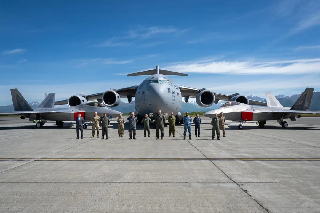 圖左穿著西裝的吳佳興少將，與其他國家軍官站在F-22戰機、C-17運輸機前方合影。(圖/美國太平洋空軍X)