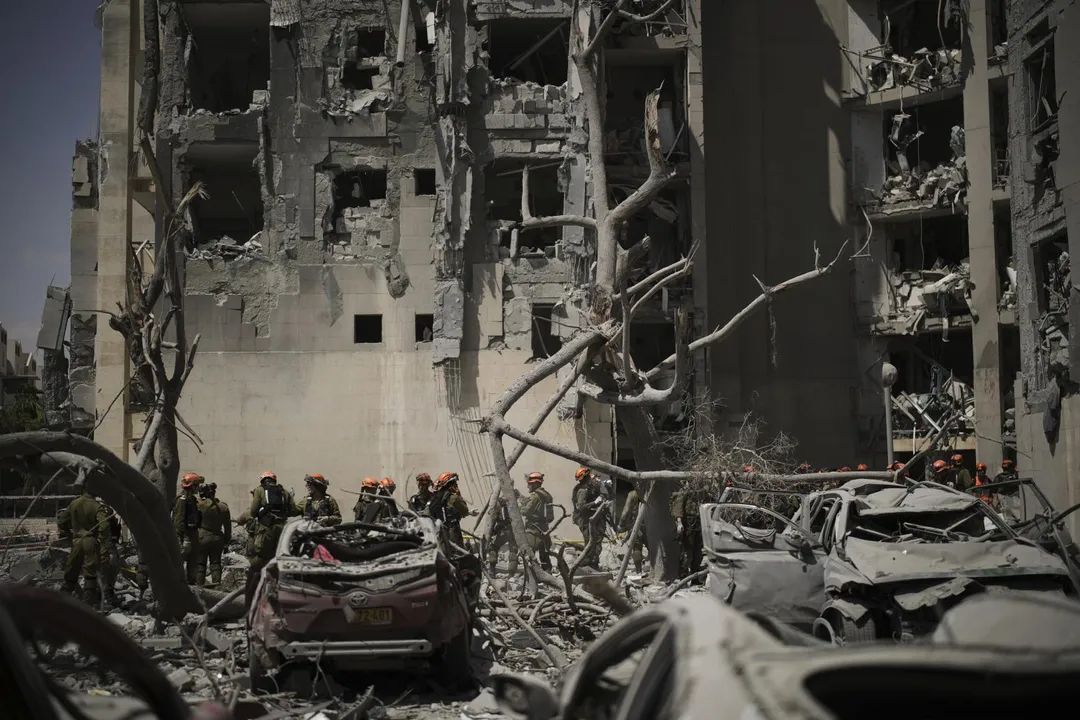 6月24日，以色列士兵在該國南部貝爾謝巴（Beer Sheva）遭伊朗飛彈襲擊的大樓現場作業。（圖／美聯社）