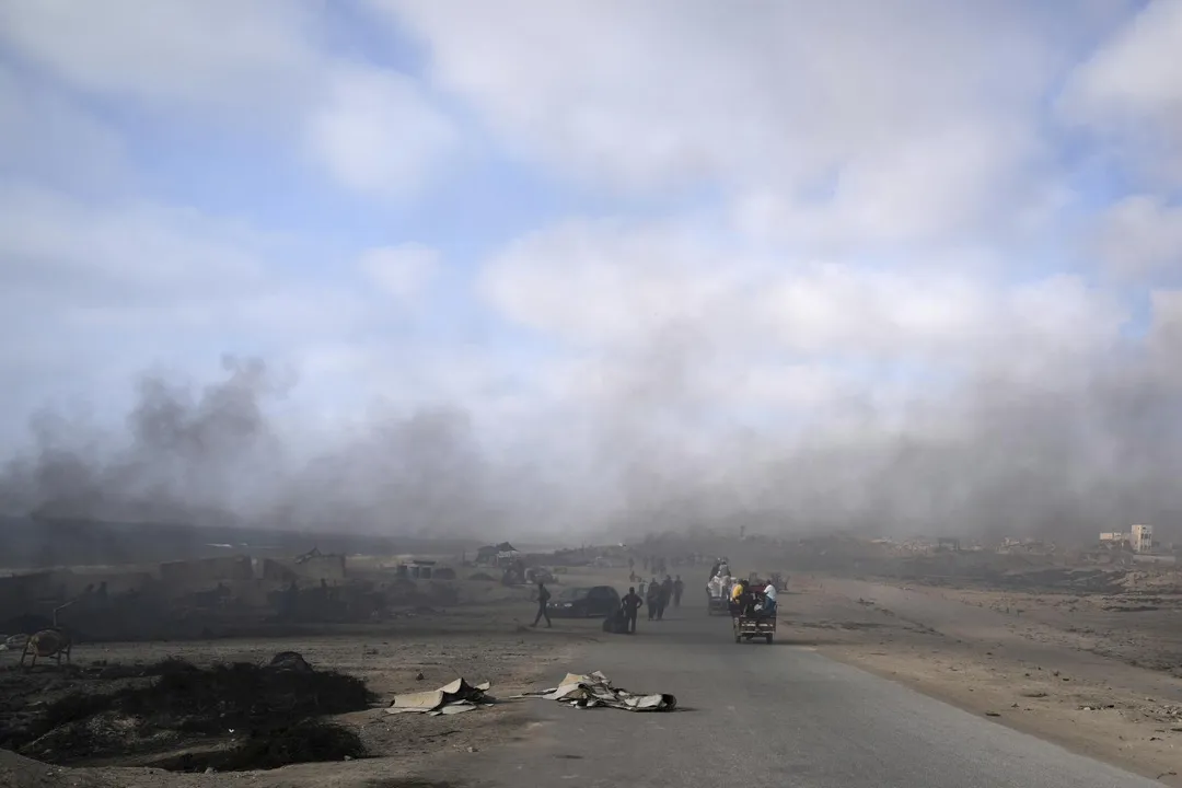 當地居民沿著加薩城南部海邊道路移動，空氣中充滿劣質汽油的黑煙。（圖／美聯社）
