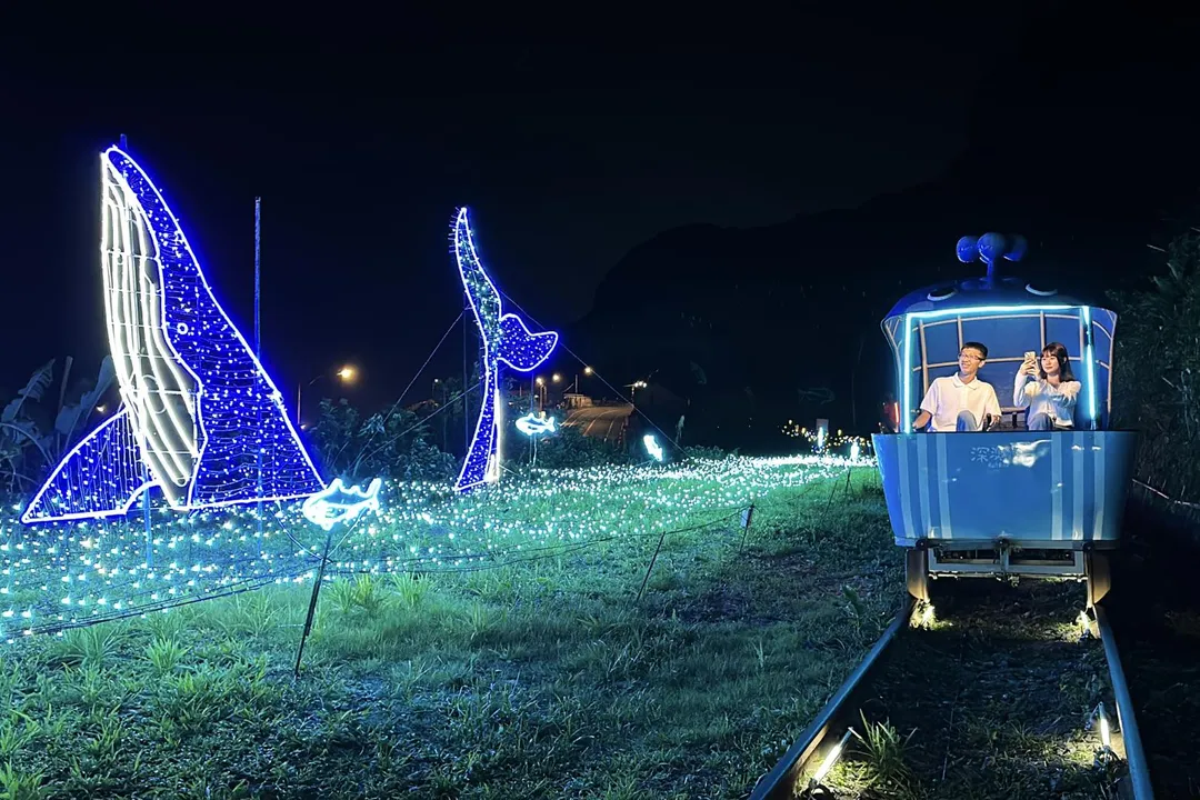 新北市深澳鐵道今年以「鯨夏夜語」為主題,透過燈光裝飾呈現獨特自行車騎行樂趣。(圖/新北市觀光局提供)