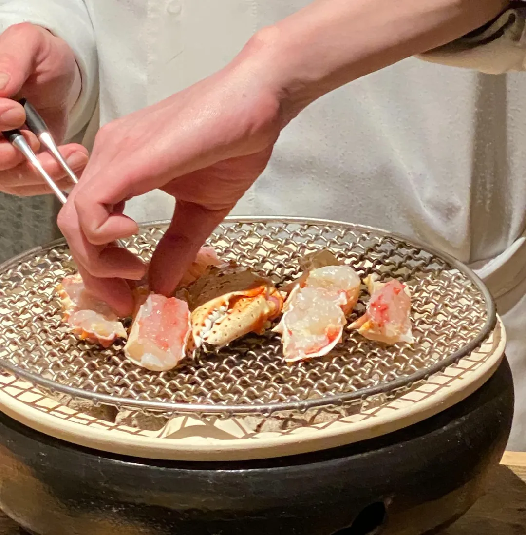 日籍師傅在桌邊料理炭火燒鱈場蟹。（圖／黃宏輝提供）