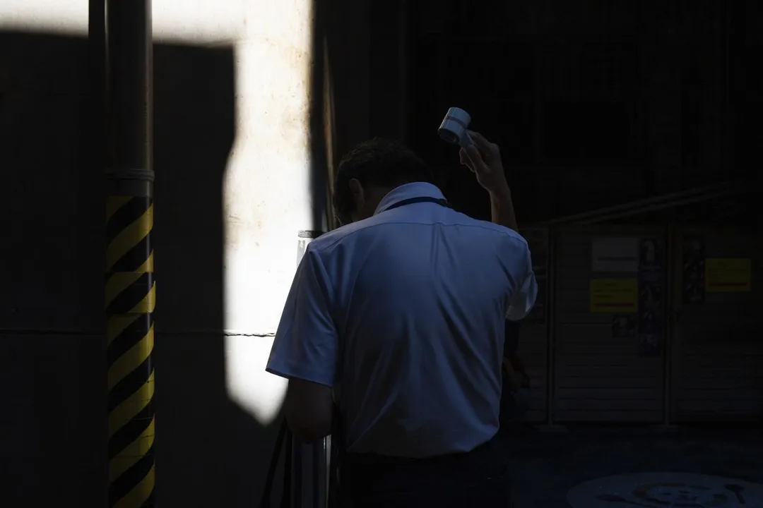 圖為一名男子在東京街頭用手持風扇避暑。（資料照／美聯社）