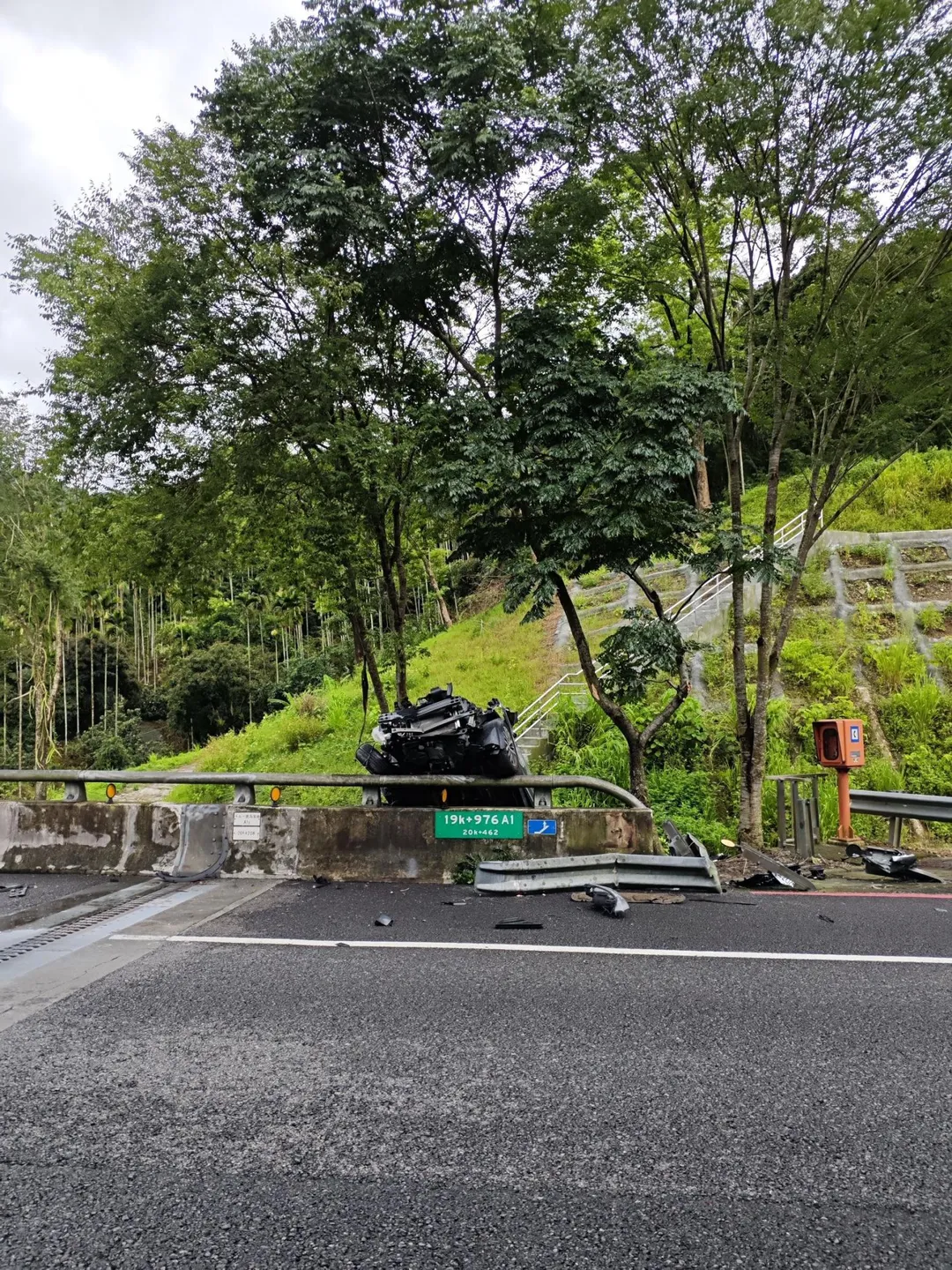 國道六號一輛灰色休旅車追撞前方銀色轎車後衝撞護欄,車輛懸掛在護欄外。令人意外的是,肇事駕駛不僅未查看車況,反而在路肩盤腿打坐。(圖/翻攝畫面)