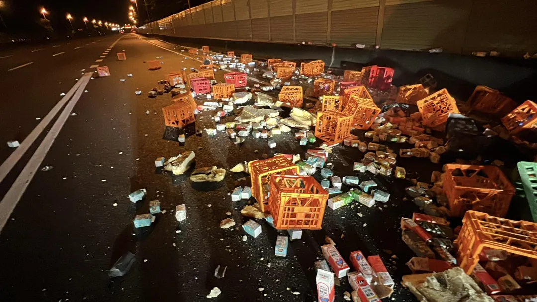 載滿牛奶、飲料的半聯結大貨車翻覆，貨物散落一地。（圖／警消提供）