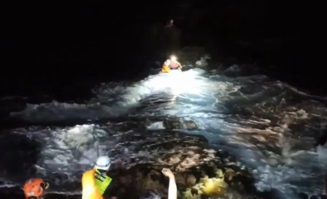 救援人員在現場架設繩索系統，涉水挺進至受困地點，釣客帶回安全區域。（圖／翻攝畫面）