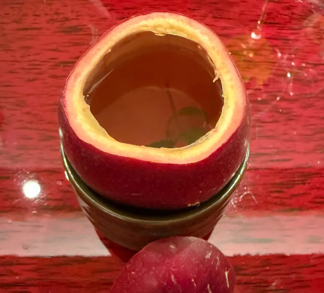 溫熱東方美人茶泡在百香果殼，透出絲絲百香果氣味。（圖／黃宏輝提供）