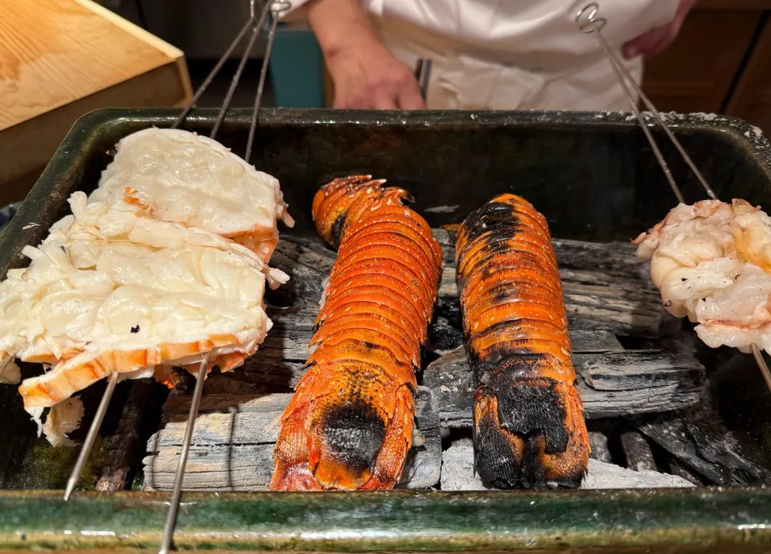 龍蝦殼藏在龍蝦肉下，透過炭火讓焦香氣味燻入肉中。（圖／黃宏輝提供）