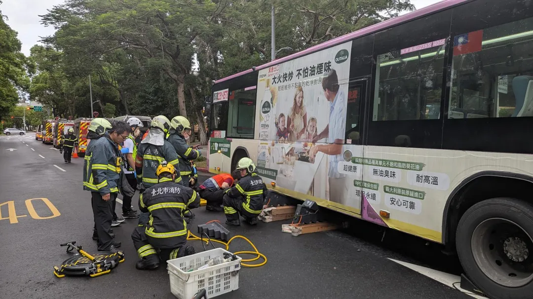 消防人員使用破壞器材撐起車體，將受困民眾救出。（圖／北市消防局提供）