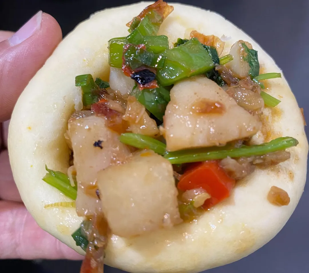 切成丁狀的佐料與綿軟的窩窩頭一同食用，具嚼勁卻不費力。（圖／黃宏輝提供）