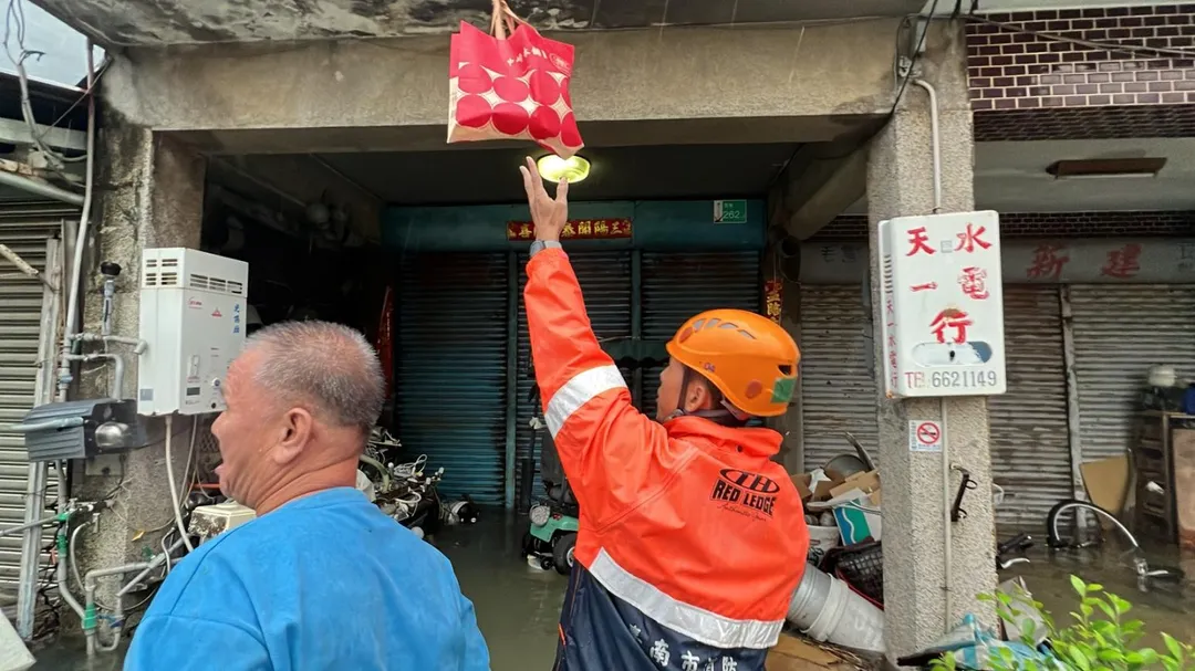 區公所人員為淹水地區災民送餐。(圖/台南市政府)