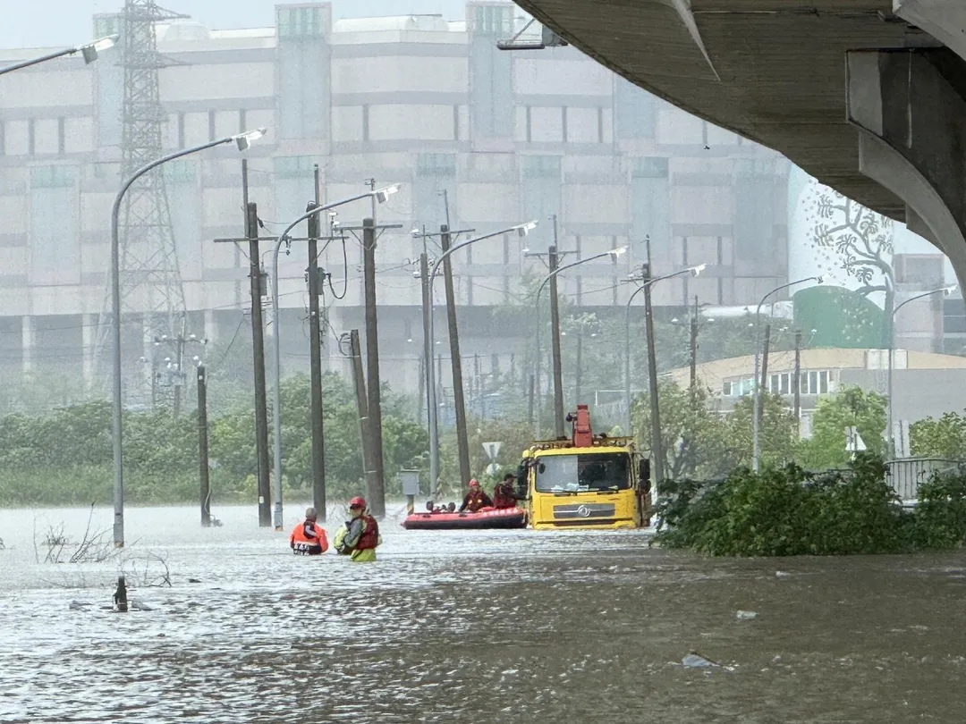 今（28）日嘉義縣再遭大豪雨侵襲，朴子市累計雨量已超過400毫米，台電工程人員在進行電力維修時受困。（圖/消防局提供）