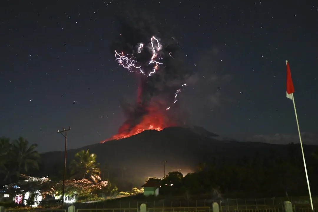 印尼雷沃特比火山1日噴發，伴隨閃電劃過，火山物質噴湧而出。 （圖/美聯社）