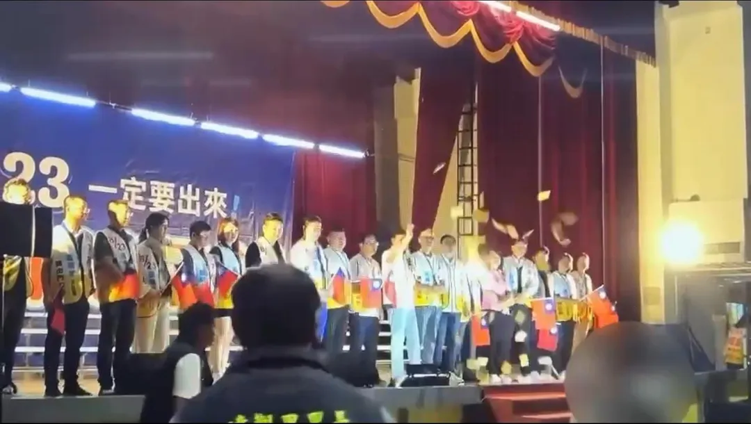 羅明才在台上宣講時男子撒冥紙鬧場。（圖／翻攝畫面）