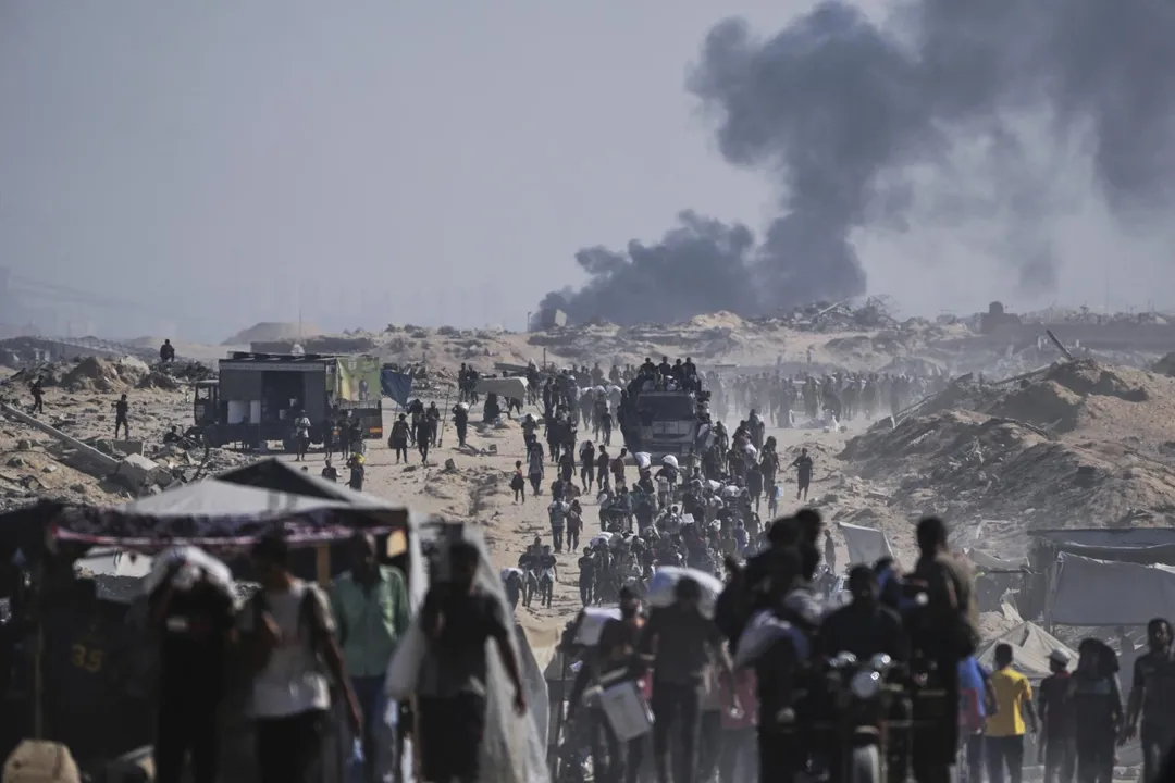 巴勒斯坦人在加薩北部貝特拉希耶（Beit Lahiya）郊區搬運從人道援助車隊卸下的麵粉袋。（圖／美聯社）