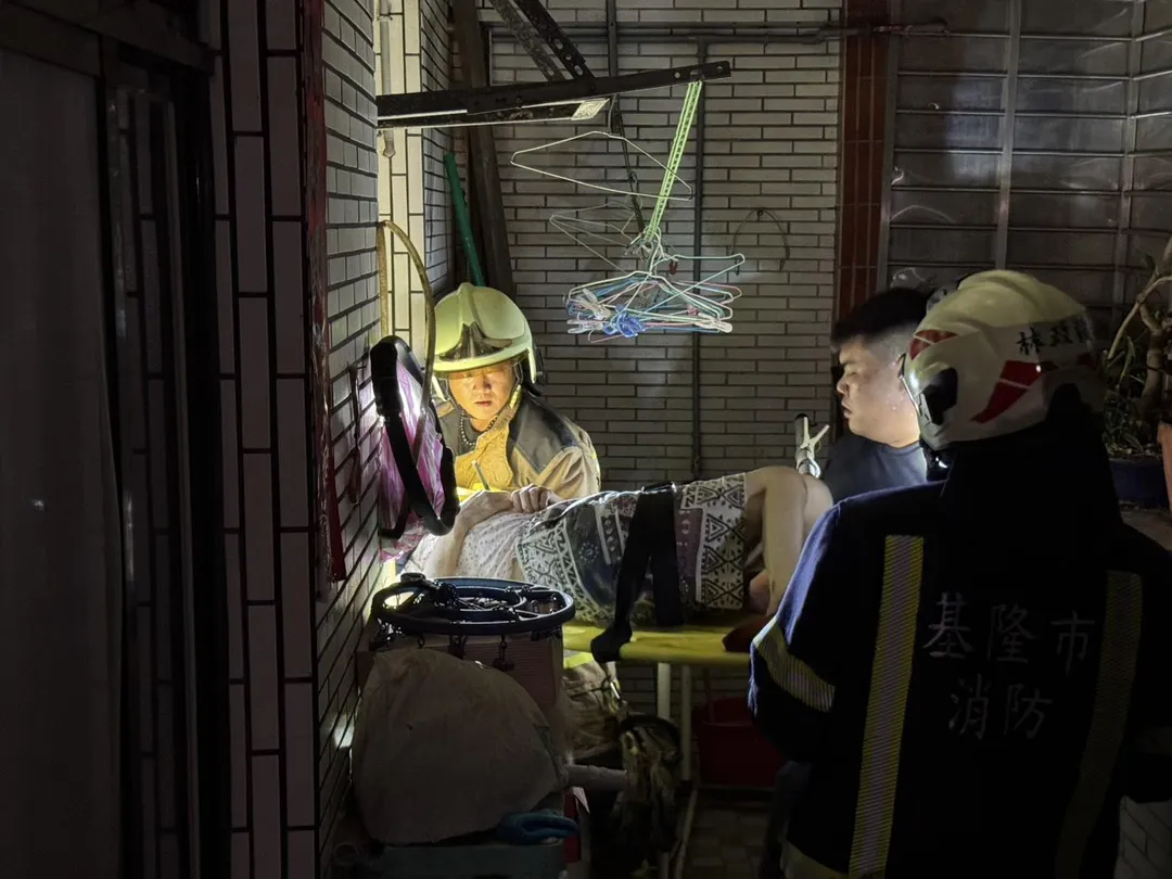 3樓住戶因客廳天花板崩塌，無法從大門正常進出。由消防員協助從窗戶，將臥床的老太太搬運出屋外，送往飯店安置。（圖/翻攝畫面）