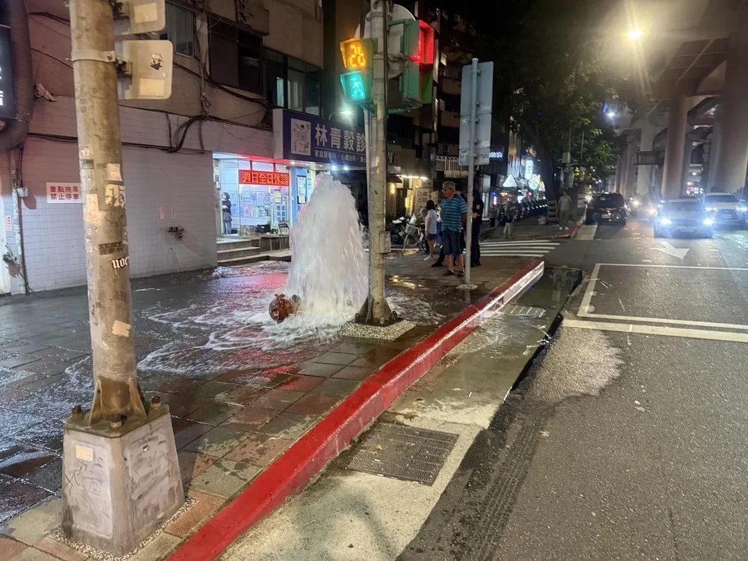 吊車駕駛未注意人行道上的消防栓，當場撞斷栓體導致大量自來水噴湧。（圖／翻攝畫面）