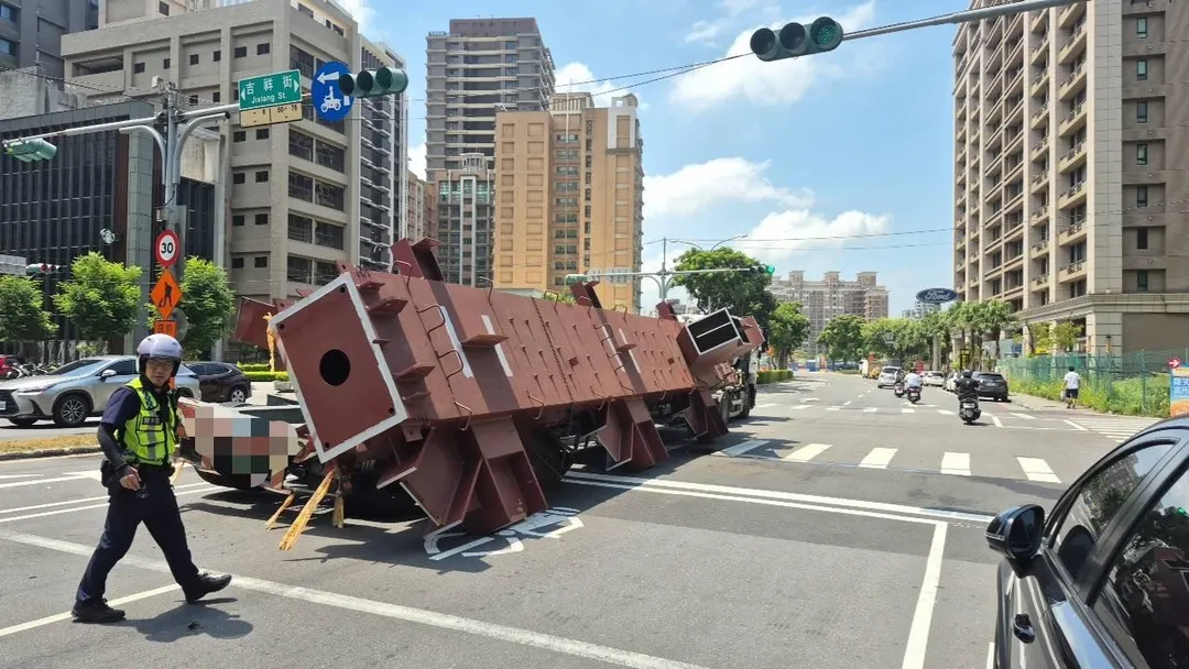 聯結車載運鋼梁行經三重區吉祥街與集賢路口時,鋼梁突然脫落重砸路面。(圖/警方提供)