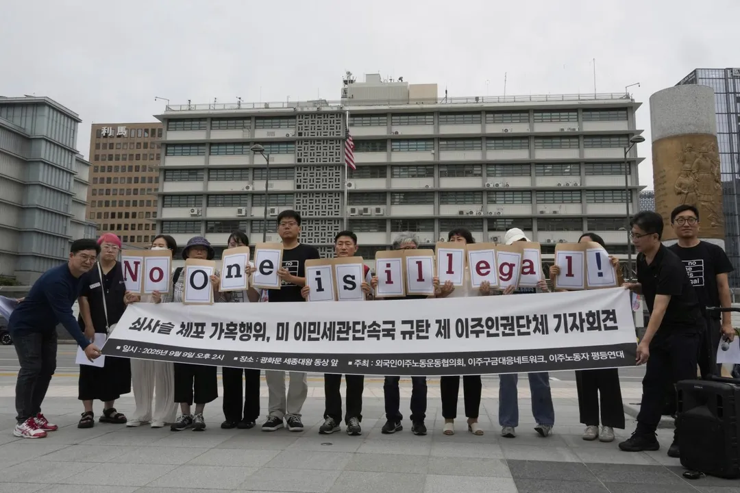 抗議者在首爾的美國大使館附近舉著寫有「譴責美國移民執法」的標語。（圖／美聯社）
