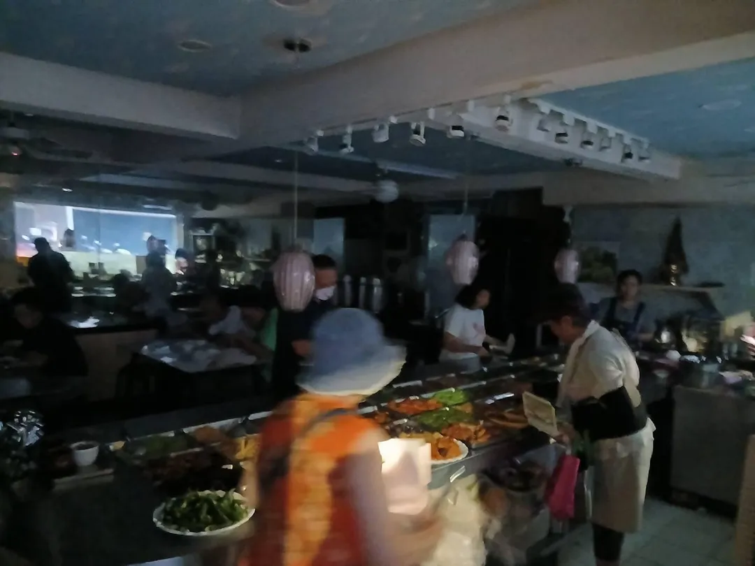 台北市信義區吳興街一帶11日晚間發生停電，自助餐店內的民眾在黑暗中夾菜。（圖／記者許元馨攝）
