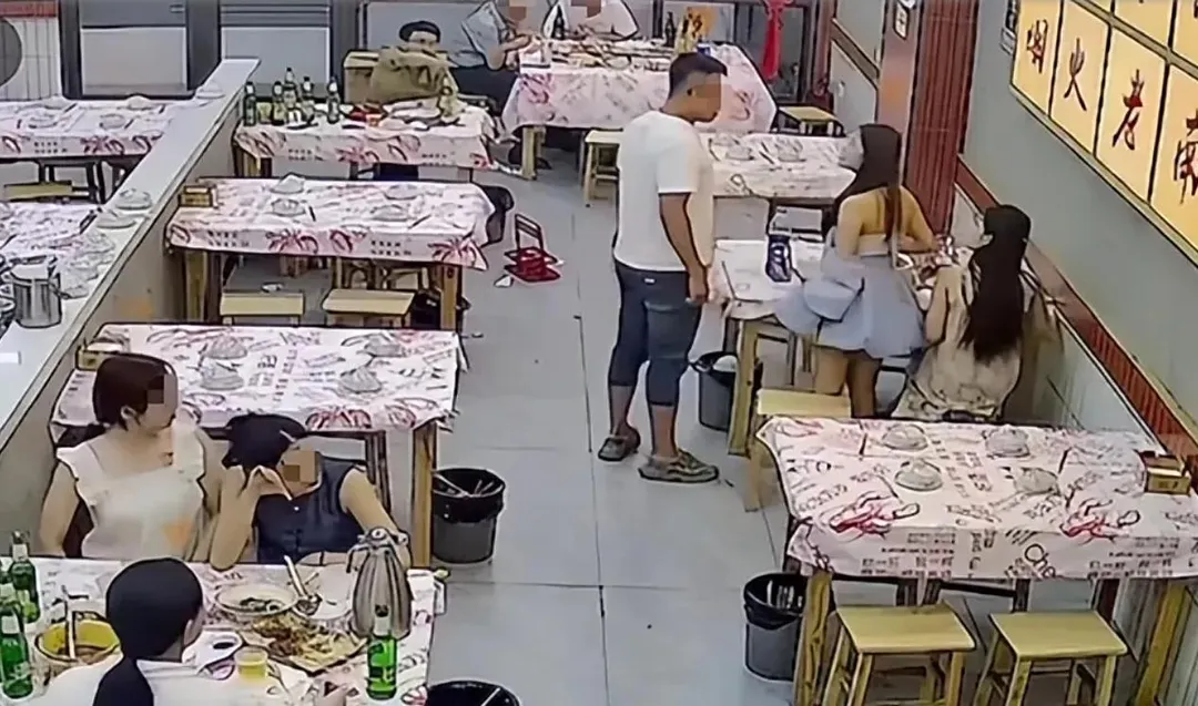 據店家監控畫面顯示白衣男子用手摸了陌生女子頭部，隨後兩人發生爭執。（圖／網路）