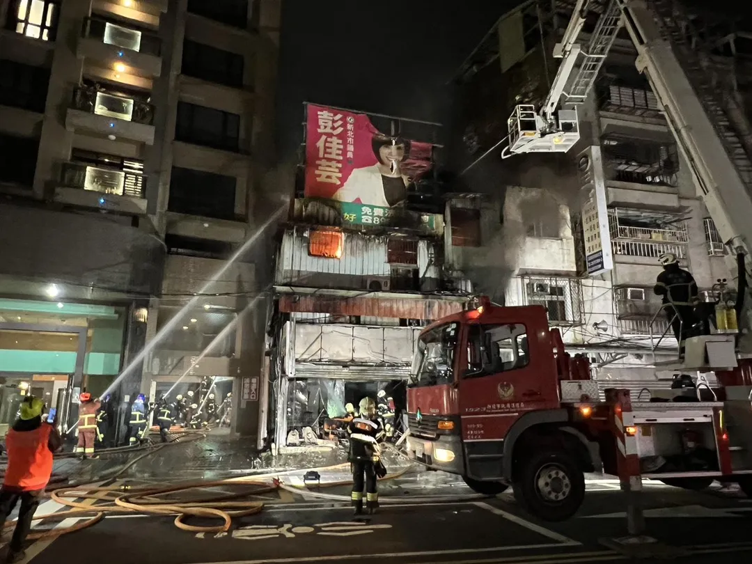 新北市三重環河南路晚間驚傳火警,消防隊員獲報到場灌救,同時呼籲附近居民緊閉門窗。(圖/新北市消防局提供)