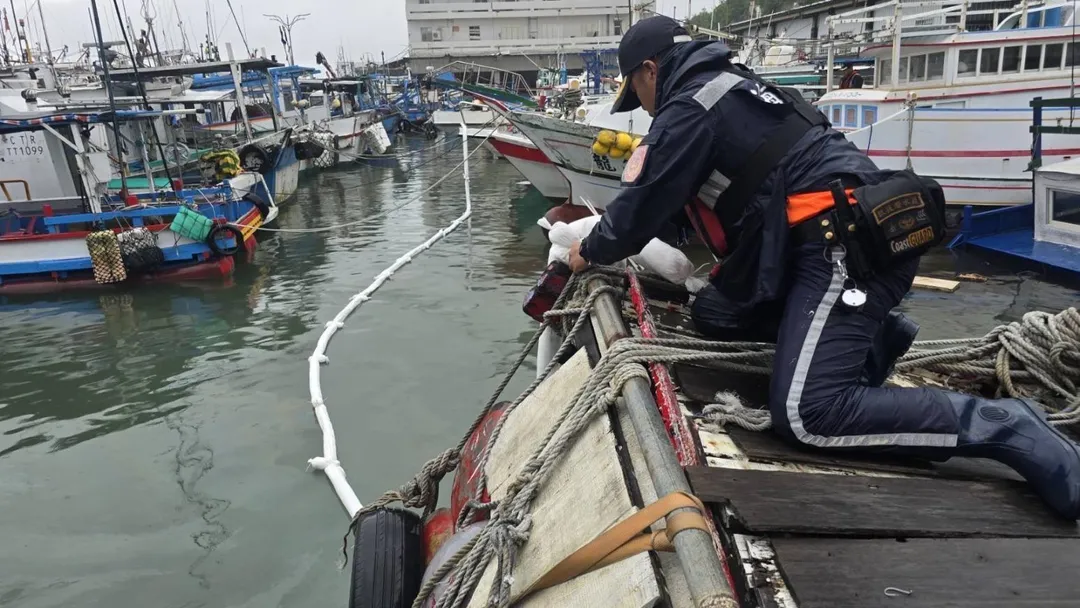台東富岡漁港一艘漁船半沉且柴油外洩，海巡人員使用棉片和攔油索，阻止污染擴大。（圖/中天新聞）