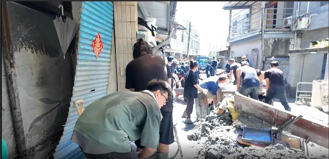 在敦厚街、中正路等地,隨處可見拿著工具、穿著雨鞋的志工們忙碌的身影。(圖/中天新聞)