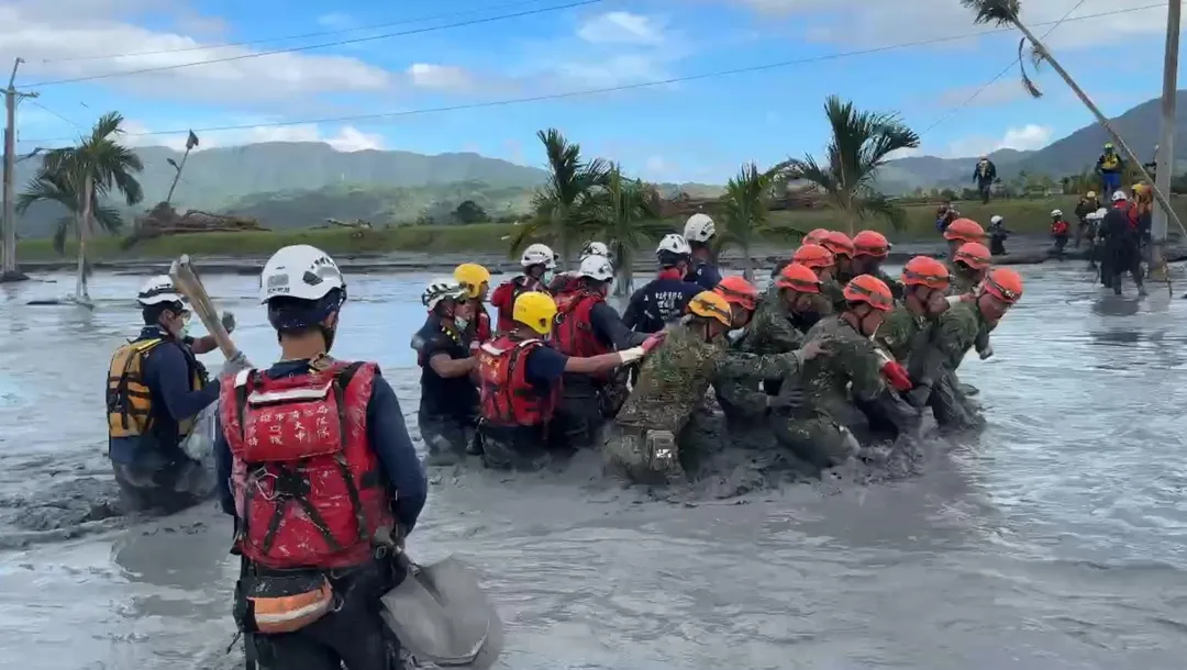 高市特搜隊員和國軍弟兄，尋獲黃姓阿嬤遺體，將近20人橫渡急流，將遺體帶出現場。（圖/高雄市消防局提供）