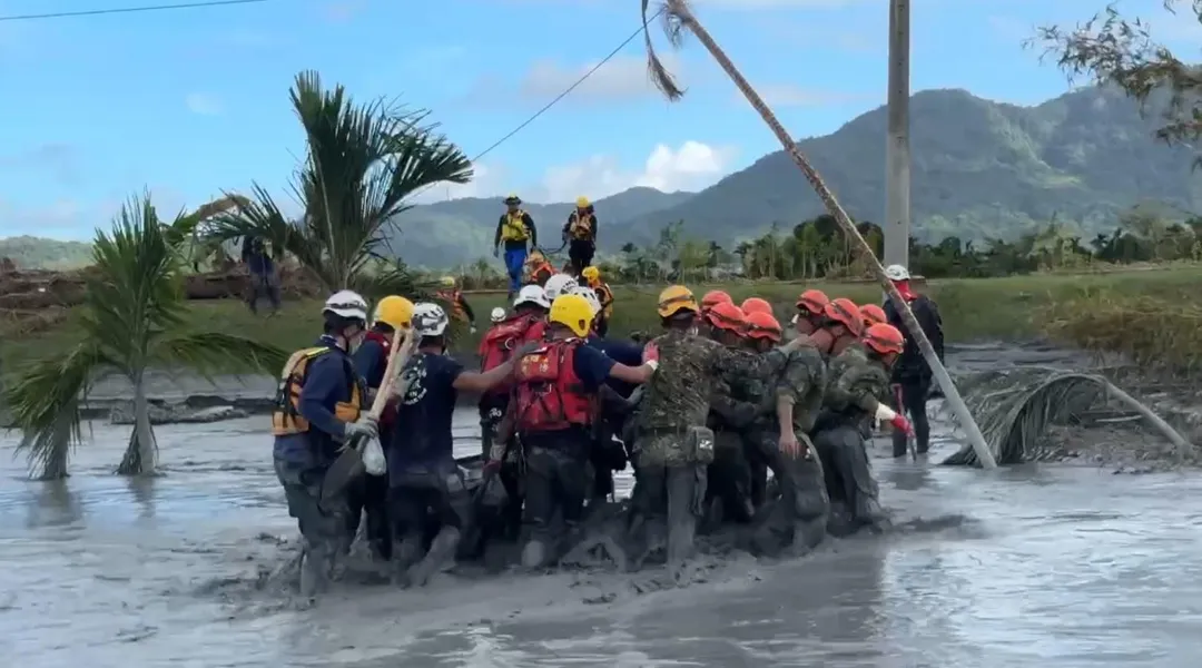 為了將黃姓阿嬤的遺體帶離，將近20名特搜隊員和國軍弟兄，靠人鏈方式橫渡急流。（圖/高雄市消防局提供）