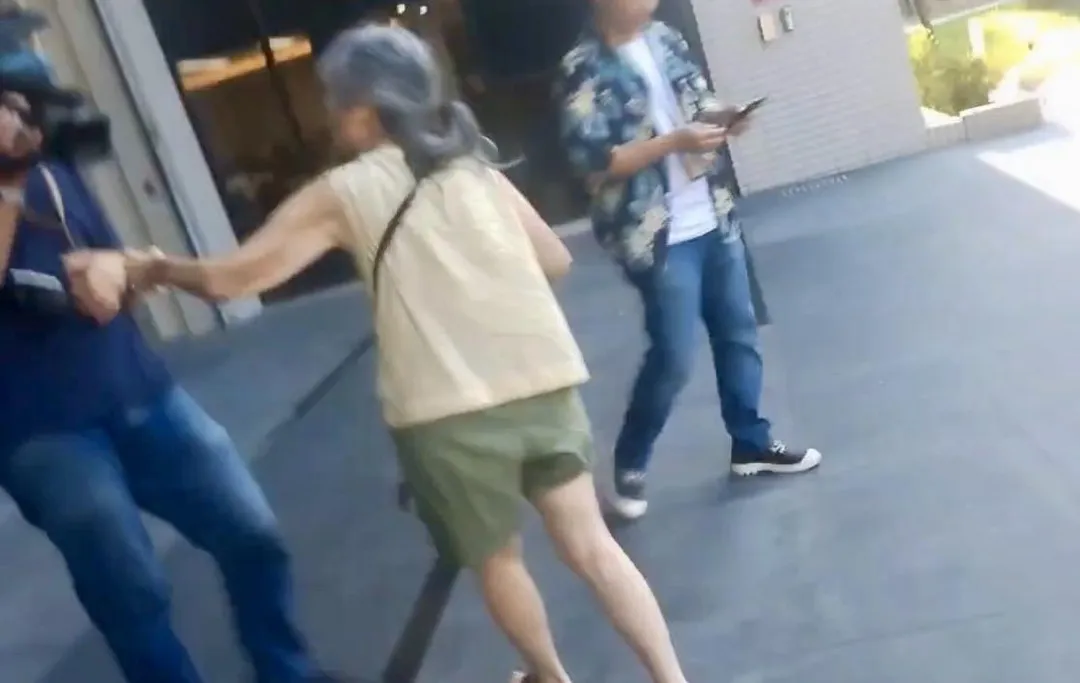曾婦懷疑記者身分在士檢門口追著記者跑。（圖／翻攝畫面）