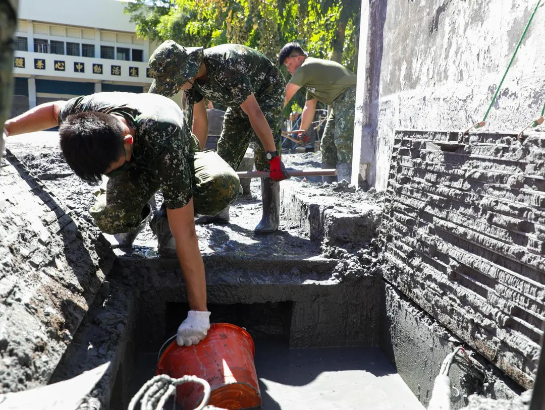 官兵協助受災學校的排水溝清淤。(圖/國防部)