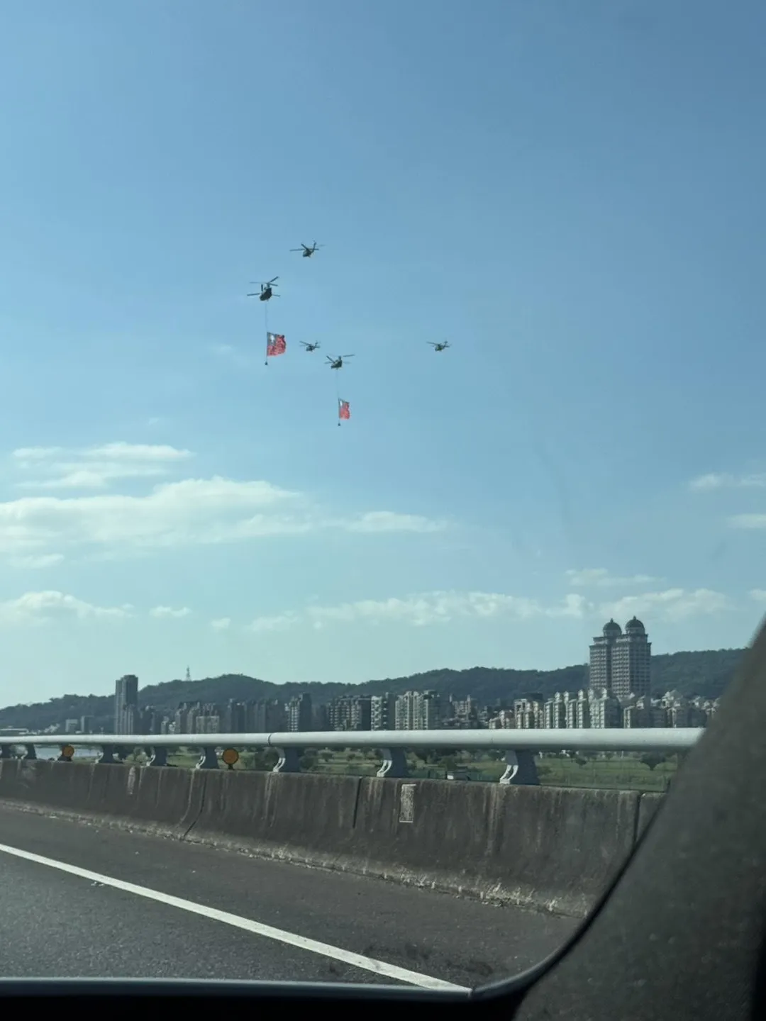 有民眾在6日下午行駛國道汐止五楊高架路段拍到直升機吊掛巨幅青天白日滿地紅國旗的壯觀場面。(圖/讀者鍾小姐提供)