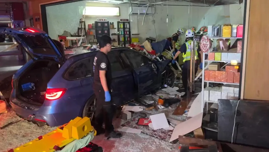 轎車暴衝撞進民宅，玻璃碎裂滿地，駕駛受困車內，消防隊員搶救卡在車頭的婦人。（圖／中天新聞）
