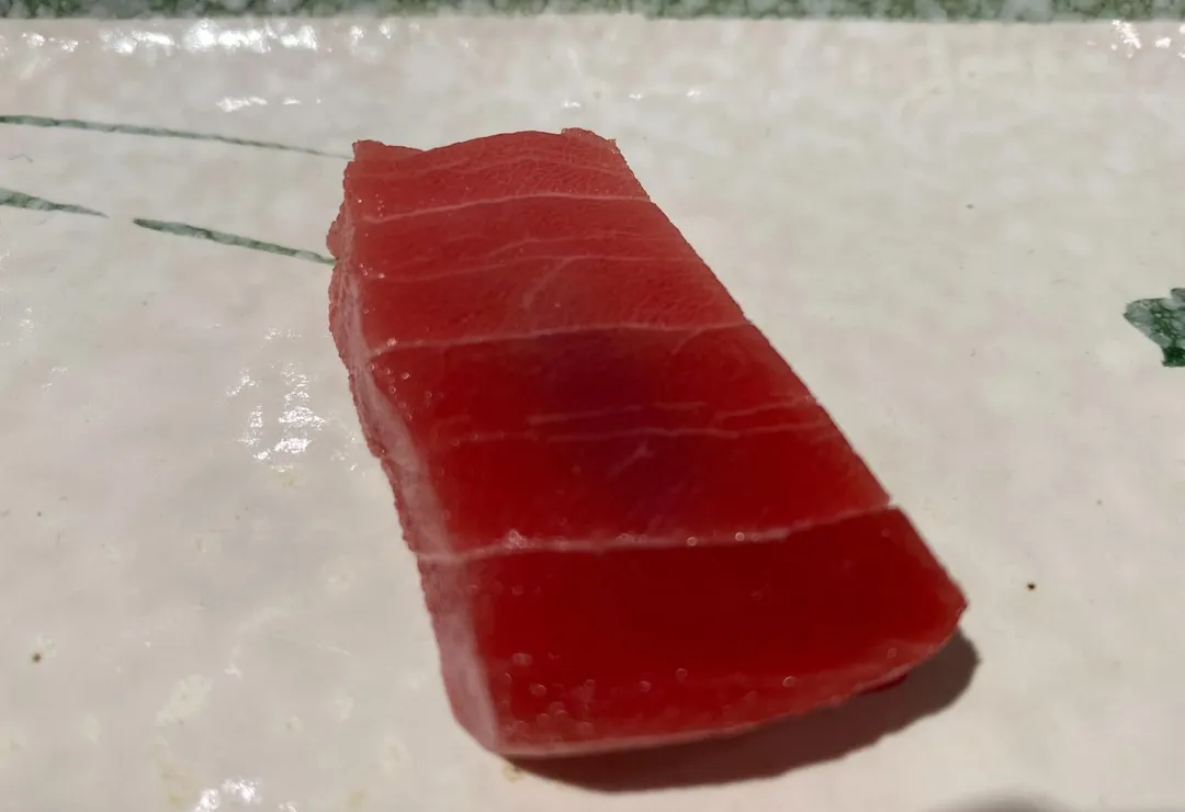 「勤謙」使用的黑鮪魚赤身需經5天熟成,去除多餘水分更顯口感綿密乾爽。(圖/黃宏輝提供)