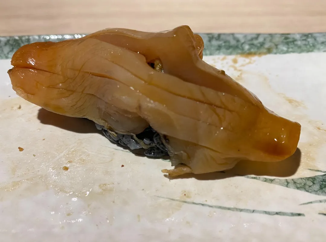 血紅色赤貝肉放上竹炭粉醋飯成為握壽司,紅黑對比產生特殊視覺效果。(圖/黃宏輝提供)