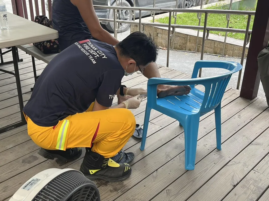 台南特搜醫療站成員，安南醫院的詹明勳醫師及陸乃甄主任等三位護理師隨隊前往災區，協助志工清除雙腳水泡。（圖／台南市消防局提供）