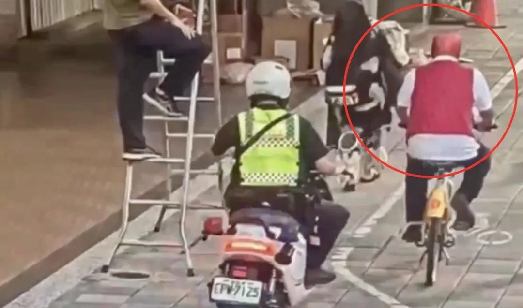 男子頭戴蜘蛛人頭套騎Ubike遭警方攔查。(圖/翻攝畫面)