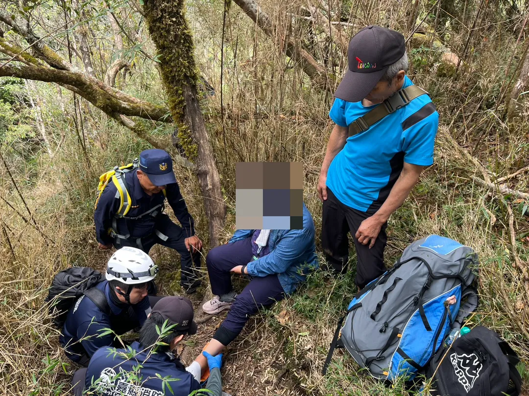 台南市一對夫妻11日至阿里山攀登路況較陡峭的兒玉山路線，不料妻子不慎摔倒導致左腳踝疑脫臼，嘉義消防人員獲報上山援救山。（圖／嘉義縣消防局提供）