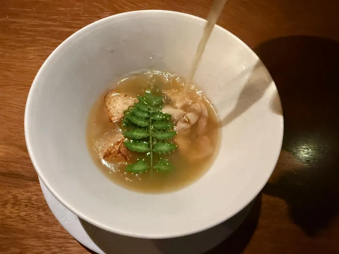 熬雞湯上漂浮川燙過的過貓菜。（圖／黃宏輝提供）