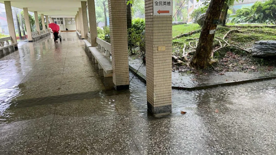 國立羅東高中校園重要通道風雨走廊因暴雨積水達30公分深，學生為了通行被迫脫掉鞋襪赤腳涉水，或改走兩側座椅避開淹水區域。（圖／國立羅東高中徐卜柔老師提供）