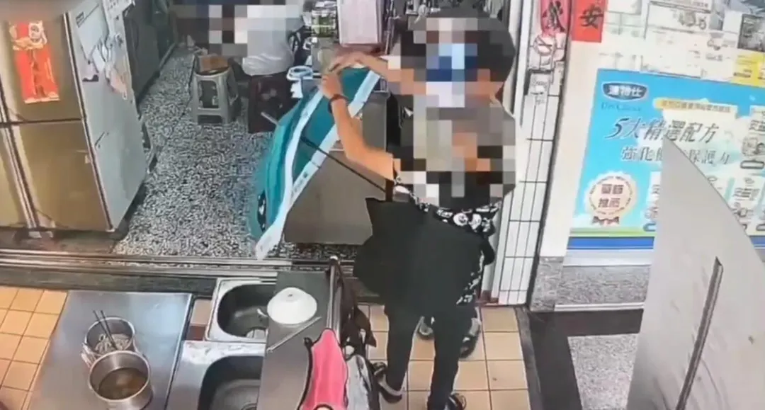 2名女賊以雨傘遮掩，偷走店家放在桌上的零錢筒，被監視器拍下。（圖／警方提供）