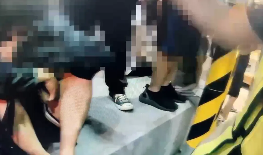 何男偷拍一名變裝成蘿莉的女大生時，被女生友人發現並立即將他團團圍住，警方到場處理。（圖／翻攝畫面）