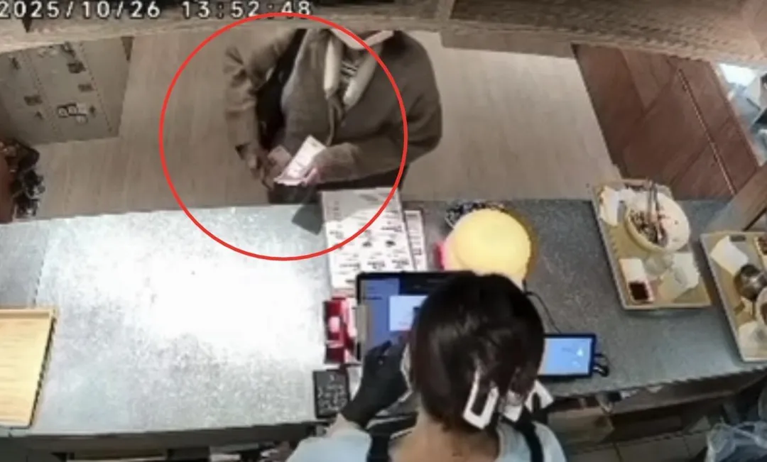 婦人迅速將500元鈔票放進口袋。（圖／翻攝畫面）