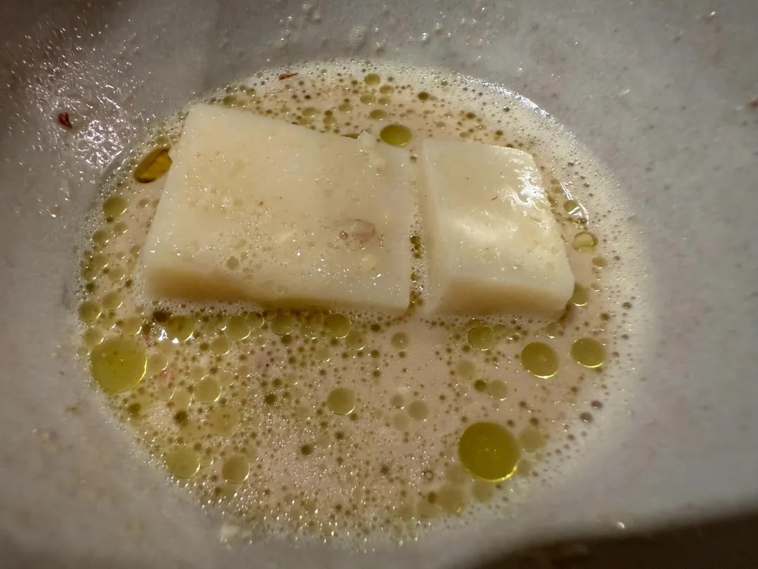 白色米麴豆腐沉在湯汁和堅果碎粒下。（圖／黃宏輝提供）