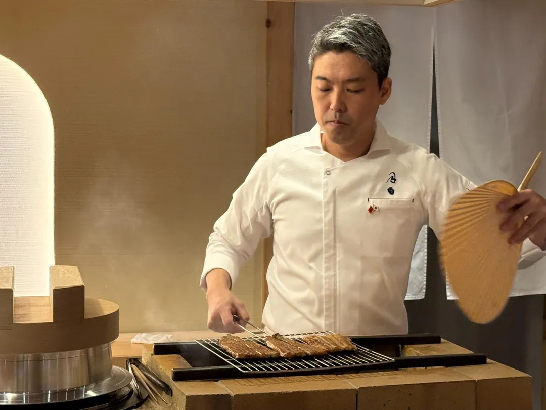 料理長小杉秀樹持蒲扇親烤鰻魚。（圖／黃宏輝提供）