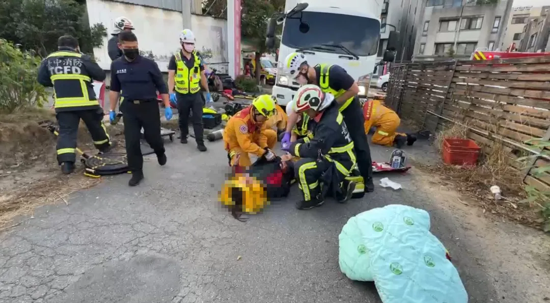 台中市上午發生嚴重車禍,機車遭物流車撞上,騎士和乘客被捲入車底,造成1死1傷。機車乘客滿臉是血被救出(圖)。(圖/中天新聞)