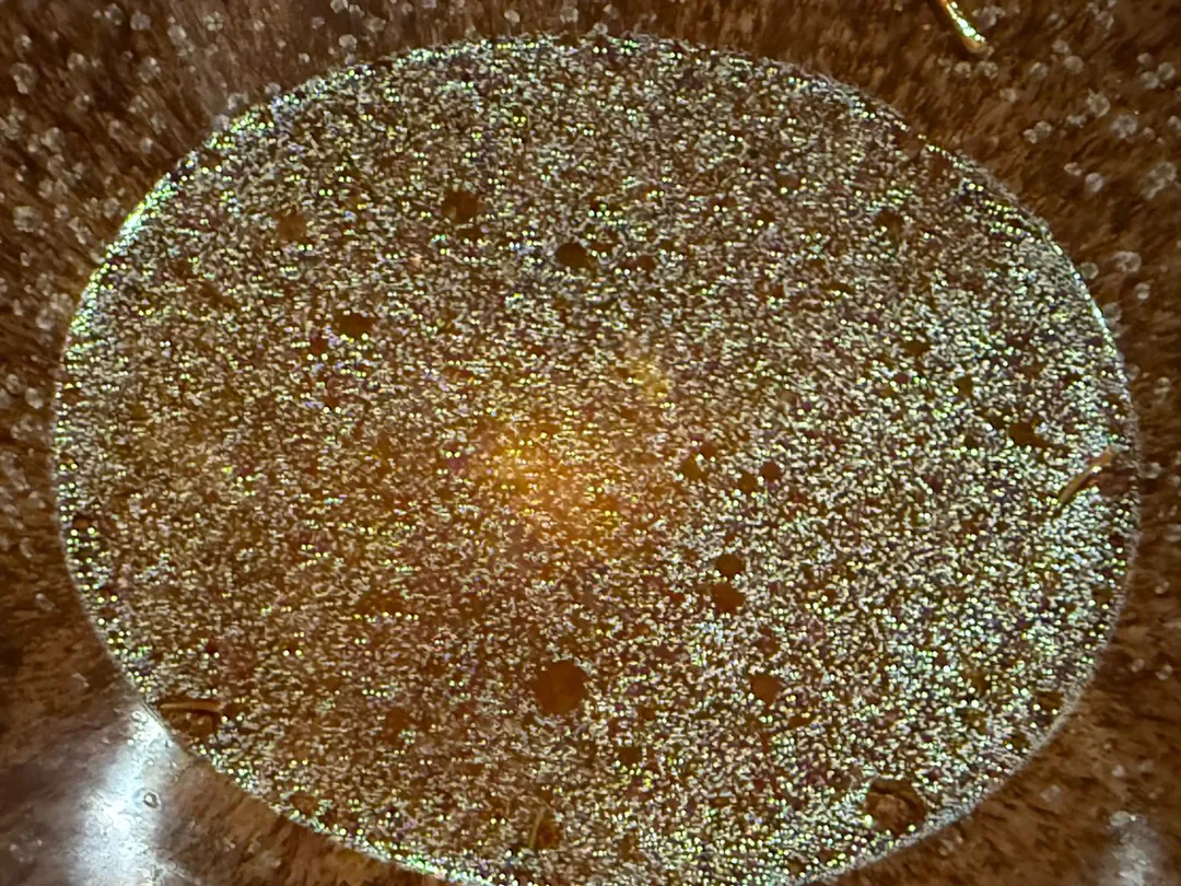 番紅花與風乾竹筴魚熬出澄清湯，湯表面的細密油滴來自銀鰈本身。（圖／黃宏輝提供）